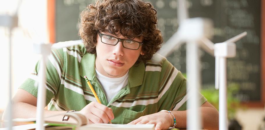 A male student studying from a book.