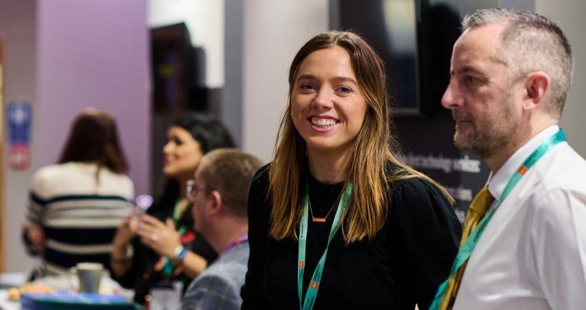 Two delegates smiling at an event.