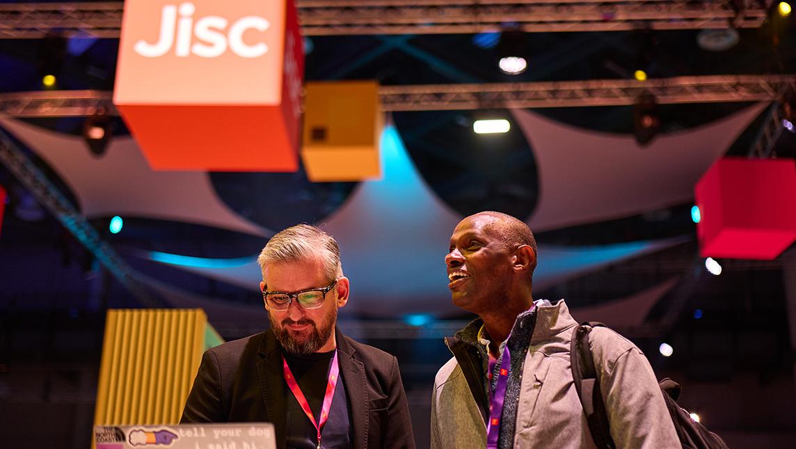 Two delegates chatting at a Jisc event.