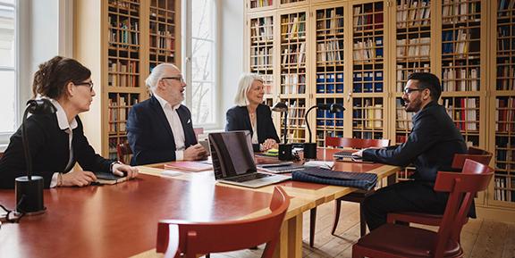 A team of university executives sitting in a meeting room.