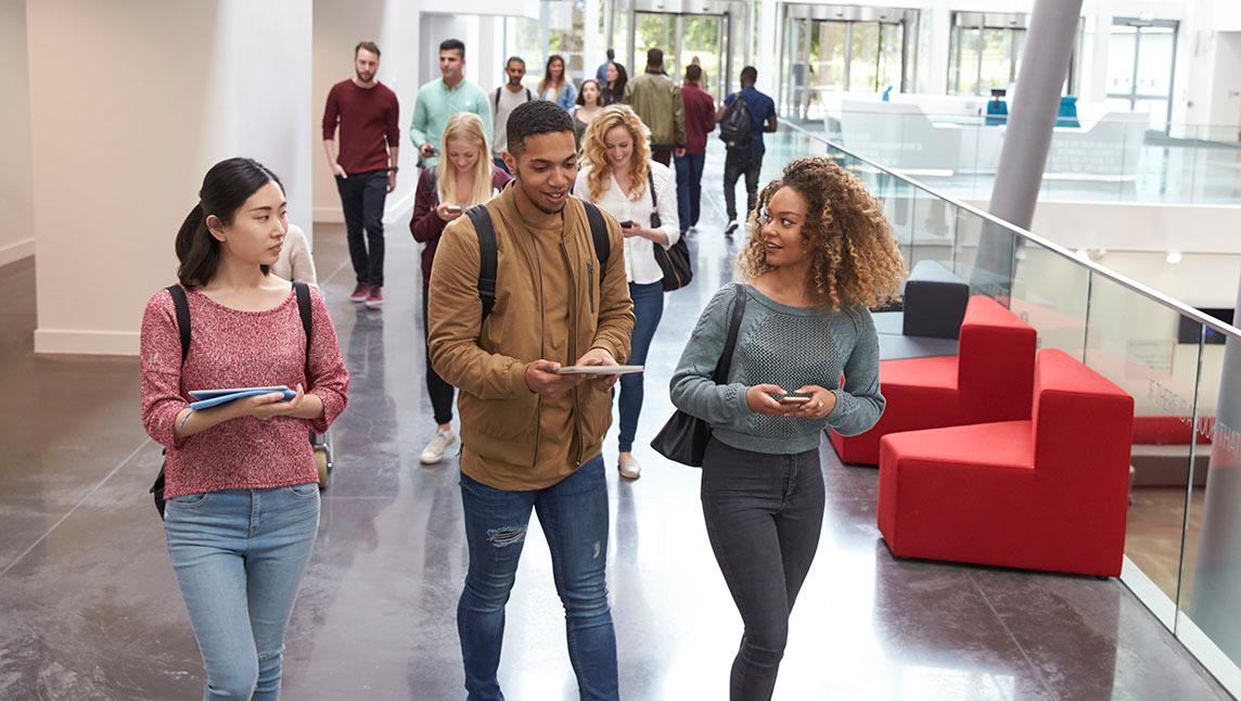 Students talking while leaving a lecture at a university.