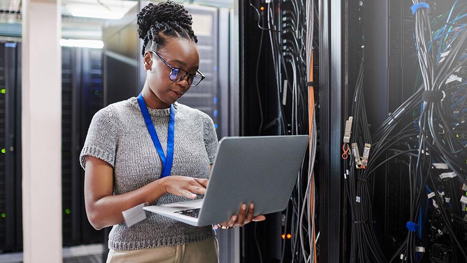 A female technician standing with a laptop.