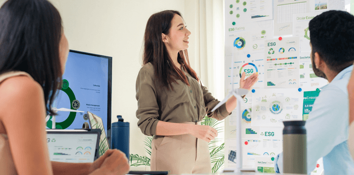 A group of employees in a meeting discussing ideas with a whiteboard
