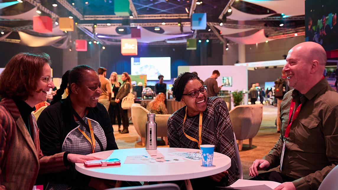 Delegates at Digifest 2025 in discussion around a table.