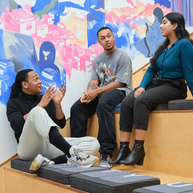 Students sit and chat in a classroom setting