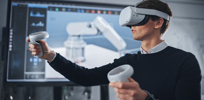 An engineer uses a virtual reality headset to draw a robotic arm.