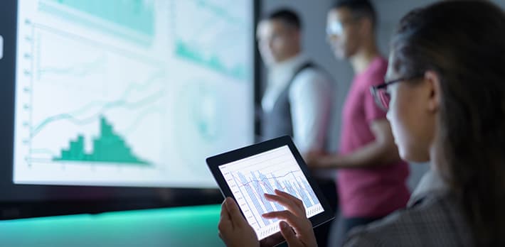 A group of people analyse data in an office.