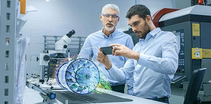 Two engineers examine a virtual reality engine turbine.