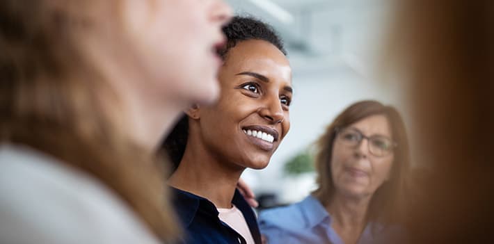 Women smile in a group discussion.