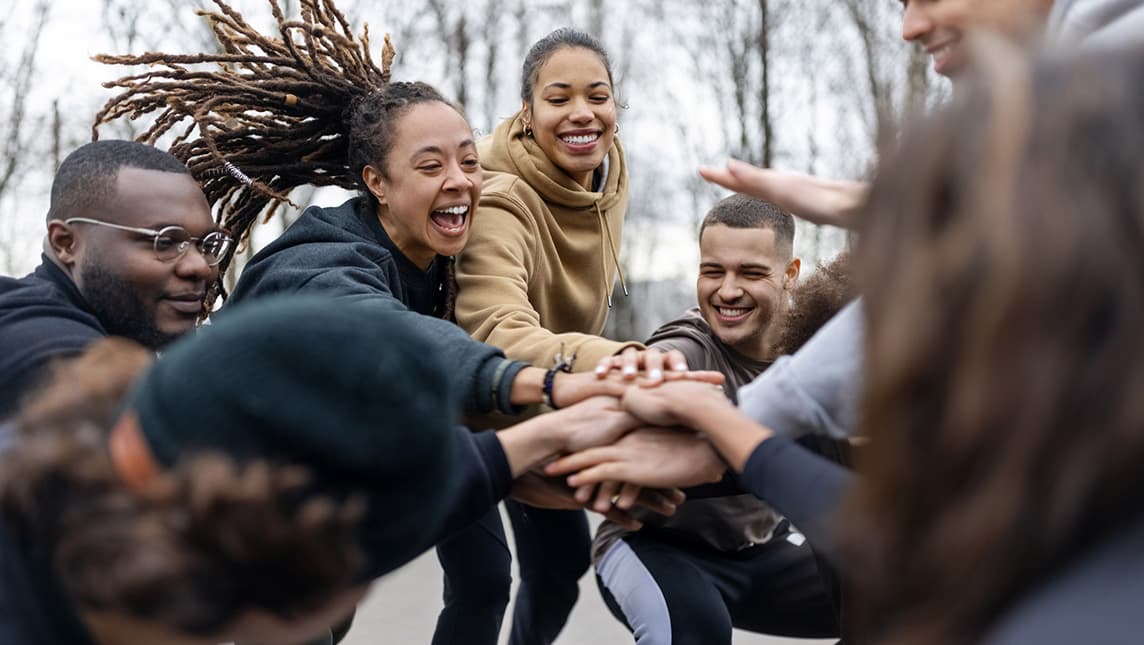A group of students touching hands