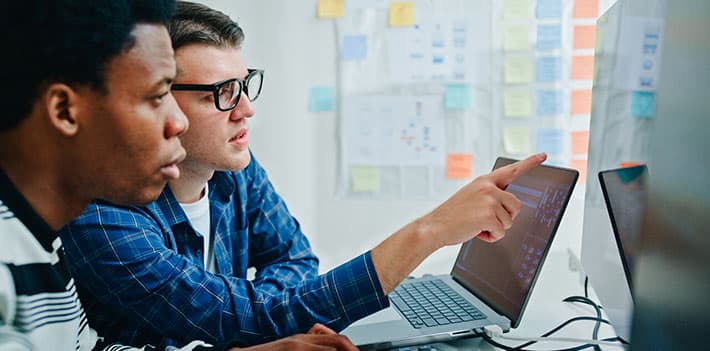 Two male IT technicians looking at a computer screen.
