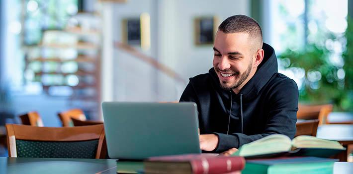 Male student studying from a laptop.