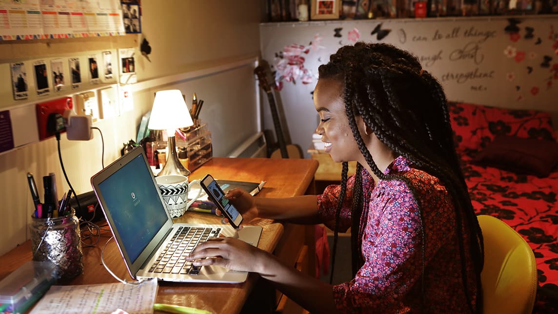 A student uses a laptop in her student accommodation.