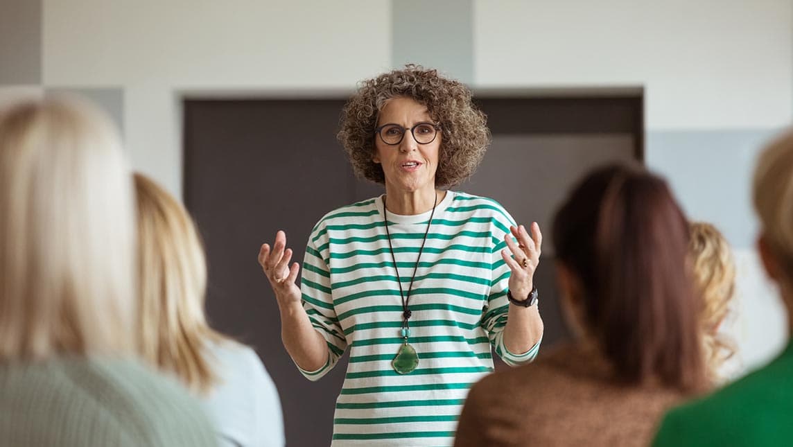 Woman presenting in front of a university group