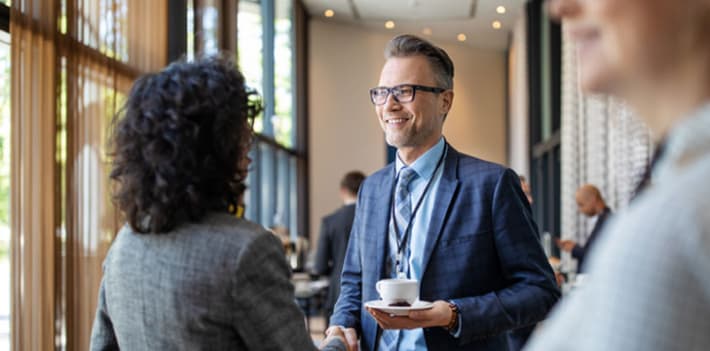 A man and women talking at an event.