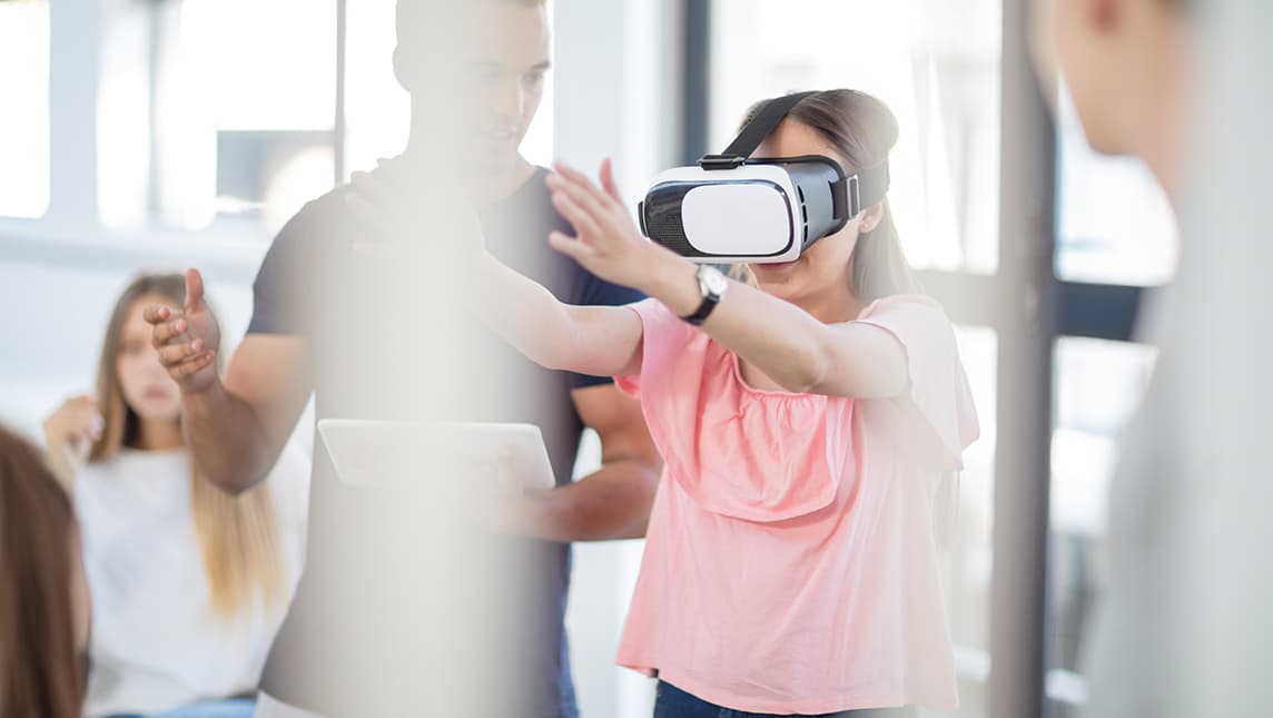 Students in a class learn from a virtual reality headset.