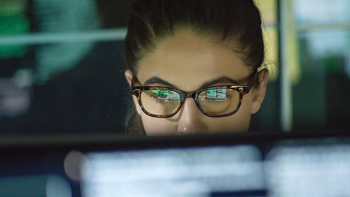 An office worker reviews data on her screen.