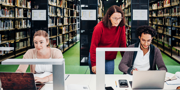 Teacher Working With her Students In Public Library