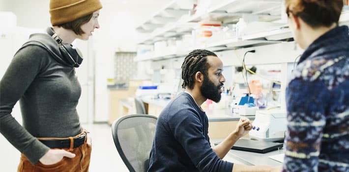 Lab researchers working collaboratively at a computer
