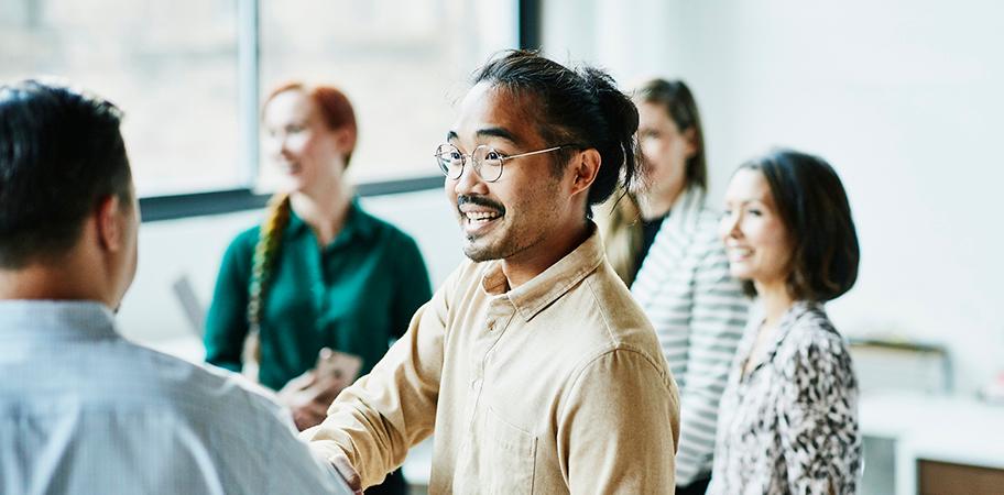 Two male staff greeting each other.