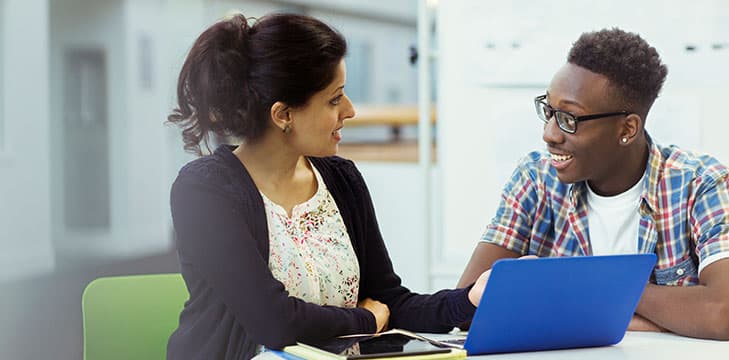 A teacher supportively discusses attendance with a student.
