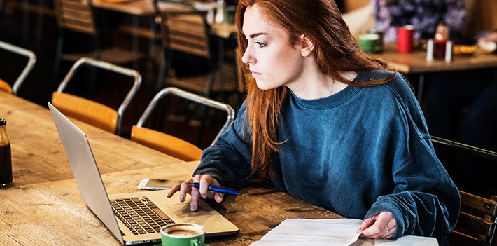 woman-looking-at-laptop-in-a-cafe-our-role-open-access-generic