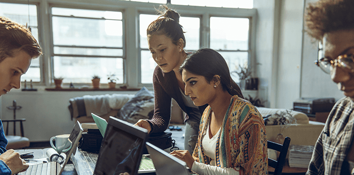 young-friends-studying-together-on-laptop-in-living-room